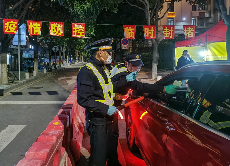 守住疫情防控的第一道防線。圖為，集美街道轄區(qū)各路口實(shí)行24小時(shí)設(shè)點(diǎn)檢測(cè)，夜間工作人員對(duì)駕駛員測(cè)量體溫（林志杰攝影）-181737.jpg